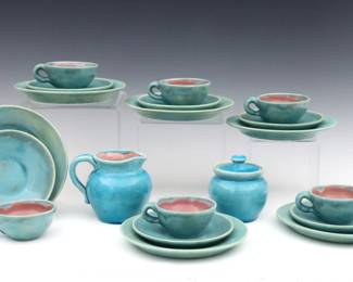Fourteen pieces of early 20th century Pisgah Forest Pottery.  Various form with Pink glazed interiors and Blue exteriors, includes six tea cups and six saucers, six dessert plates, and a creamer with covered sugar set.  Stamped "Pisgah Forest" marks, saucers and plates dated "1941", creamer and sugar dated "38".  Some crazing particularly to creamer and sugar, one saucer with hairline at rim.  Up to 6 1/2" diameter and 3 1/2" high.  ESTIMATE $100-200