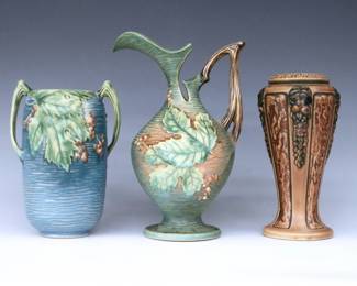 Three pieces of mid 20th century Roseville Art Pottery.  Includes a baluster form ewer with and ovoid vase with multi-color Bushberry decoration and Green/Blue matte glaze, and a baluster vase with Neoclassical "Florentine" decoration and Brown matte glaze.  Both Bushberry pieces with molded "Roseville / U.S.A." marks, ewer with "2-10" and vase with "31-7" model numbers, Florentine vase unmarked.  One Bushberry vase handle with repaired break, some areas with minor discoloration.  7 3/4" to 10 1/4" high.  ESTIMATE $50-100