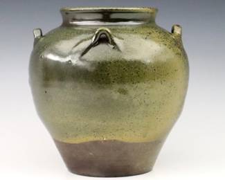 A 20th century Jugtown Pottery vase.  Chinese style urn form with applied handles and mottled Green Frogskin glaze.  Impressed "Jugtown Ware" mark.  Minor wear, production glaze imperfection at body.  6 3/4" high.  ESTIMATE $50-100