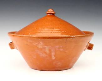 A 20th century Jugtown Pottery covered tureen.  Tapered form with conical lid, strap handles and mottled Orange glaze.  Impressed "Jugtown Ware" mark.  Crazing, a few small flakes and painted touch-ups.  11" diameter x 7 1/2" high.  ESTIMATE $50-75