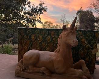Concrete Unicorn Garden Statue besides a large majolica planter box