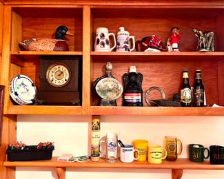 Beer steins, vintage glass liquor bottles,  ceramic duck and wooden clock 