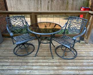 2 iron swivel rocker chairs and small round table