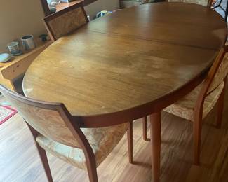 Teak table with two leaves, plus six teak chairs.