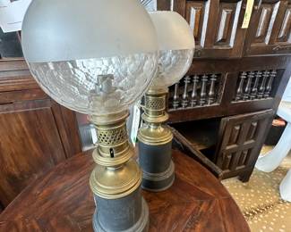 Pair of French metal oil lamps with glass globes circa 1880.