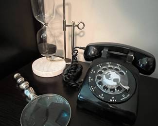 Hourglass, magnifying glass and vintage phone