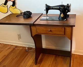 Antique singer sewing machine. Works. With wood cabinet with sliding cover 