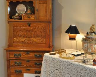 Antique oak secretary with drop down center to use as a desk with 4 drawers below. Round mirror and small drawer and closed door above. Beautiful decorated center with quartersawn wood. So versatile in a smaller space. Has its keys.