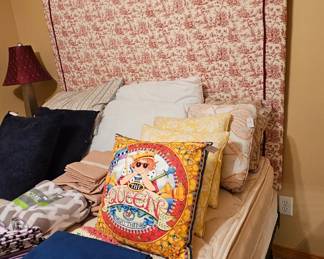 Queen size bed and headboard and many pillows.