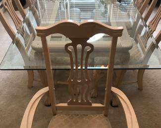 Thick beveled glass top dining room table with two cushioned captains chairs and four cushioned chairs
