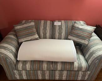 love seat with pull out bed, mattress topper, and pillows
