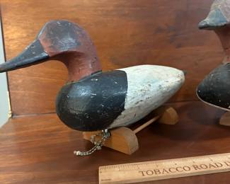 P97 - $150 Each. 2 Available (multiple photos to show angles) Unsigned Canvasback Duck Decoys. Carved wood with some age on them! Great paint. Overall very good vintage condition. One has crack around the neck area. Both have metal rings on the bottom and come with photographed stands. 