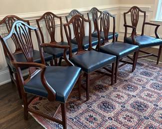 P12 - $350 Set. Set of 8 Mahogany Hepplewhite Style Dining Chairs.  Seats are blue leather. 6 side chairs: Measure 21" wide x 18.5" deep  x 39" tall. 2 arm chairs: Measure 22" wide x 18.5" deep  x 39" tall. **One captains chair has a cracked piece on the back - would need repair for regular use. 