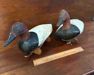 P97 - $150 Each. 2 Available (multiple photos to show angles) Unsigned Canvasback Duck Decoys. Carved wood with some age on them! Great paint. Overall very good vintage condition. One has crack around the neck area. Both have metal rings on the bottom and come with photographed stands. 