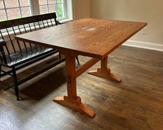 P4 - $400. Solid Wood Trestle style dining table. Has stain on the top but it's in the finish not the wood - wood is *not* warped.  Measures 48" wide x 34" deep  x 30.5" tall. 2 leaves slide into the ends and add 24" total (12" each leaf). Quality Construction! Beautiful piece - easy refinish project. 