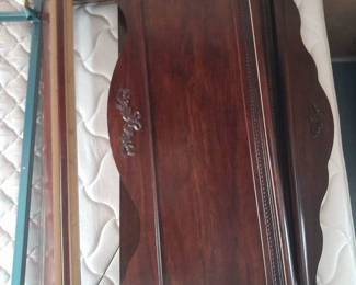 Full size bed, dark wood sleigh bed. Headboard has decorative carving in center