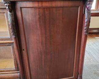 Music cabinet with ornate figural ladies and paw feet.