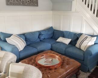 Cozy corner couch in durable denim; tufted leather ottoman table