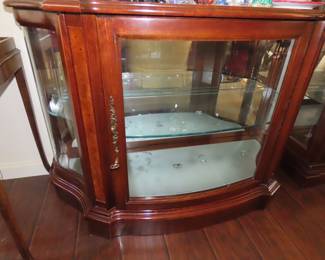 Low bow front curio with mirrored back.