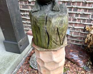 Carved frog on a tree stump.