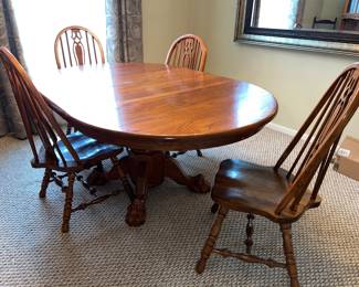 Oak Dining room table with four chairs.  Shown with two leaves inserted. Remove the two leaves and it makes a roundtable. Beautiful claw feet. $495