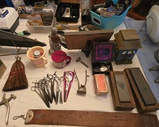 More barber supplies including a shaving mug and brush and a vintage can with a handle and louvered lid for tobacco chewers. Not shown here is a brass spittoon advertising Big Red Tobacco.