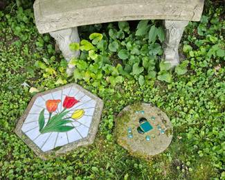 Curved cement seat and decorative stepping stones