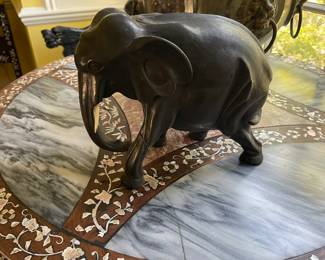 Antique wood elephant with ivory tusks, has damage to one of the legs