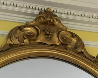 The top detail of the mirror above the mahogany console