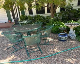 A second table with 5 chairs, birdbath, planters