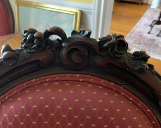 The carved details at the top of the chairs