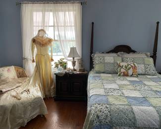 Looking at the bed showing the head board, quilt set of linens, cushions