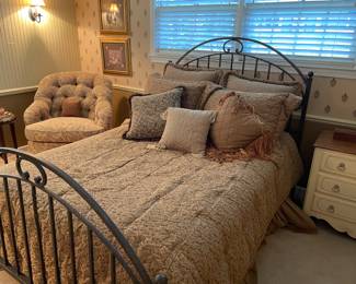 Full-size metal bed (curved head/footboard). Accent upholstered chair by Ethan Allen, nightstand/side table by Ethan Allen, framed prints and occasional pillows