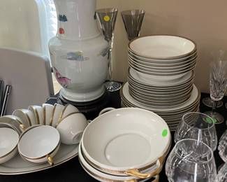 China with gold plating on rim, Asian porcelain lamp, Waterford champagne toasting flutes, and Waterford brandy glasses.