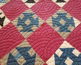 Patriotic red, white and blue quilt, hanging on rack.