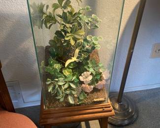 Large terrarium, and it is sitting on a little stool