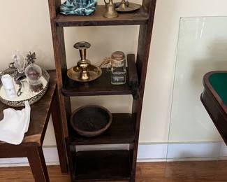 Brass candle holders on a wood 4 shelf case