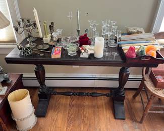 Assorted candles and candle holders on a spindle leg console table