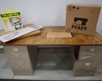 Large sewing machine table set on metal filing cabinets for storing patterns and custom plate on the right side for placing the foot pedal to allow for using your knee.