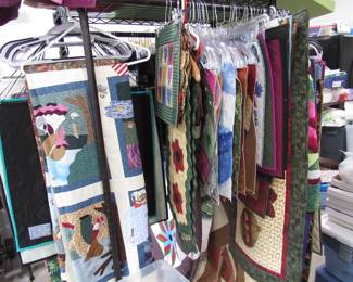 Double sided rack with completed quilts from tabletop size to wall hangings to full quilts.