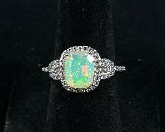 OPAL & STERLING RING | Designed as a sterling silver ring with large mounted opal bordered by melee diamond simulants, size 6, marked “925 QJ”; Total weight: 2.7g