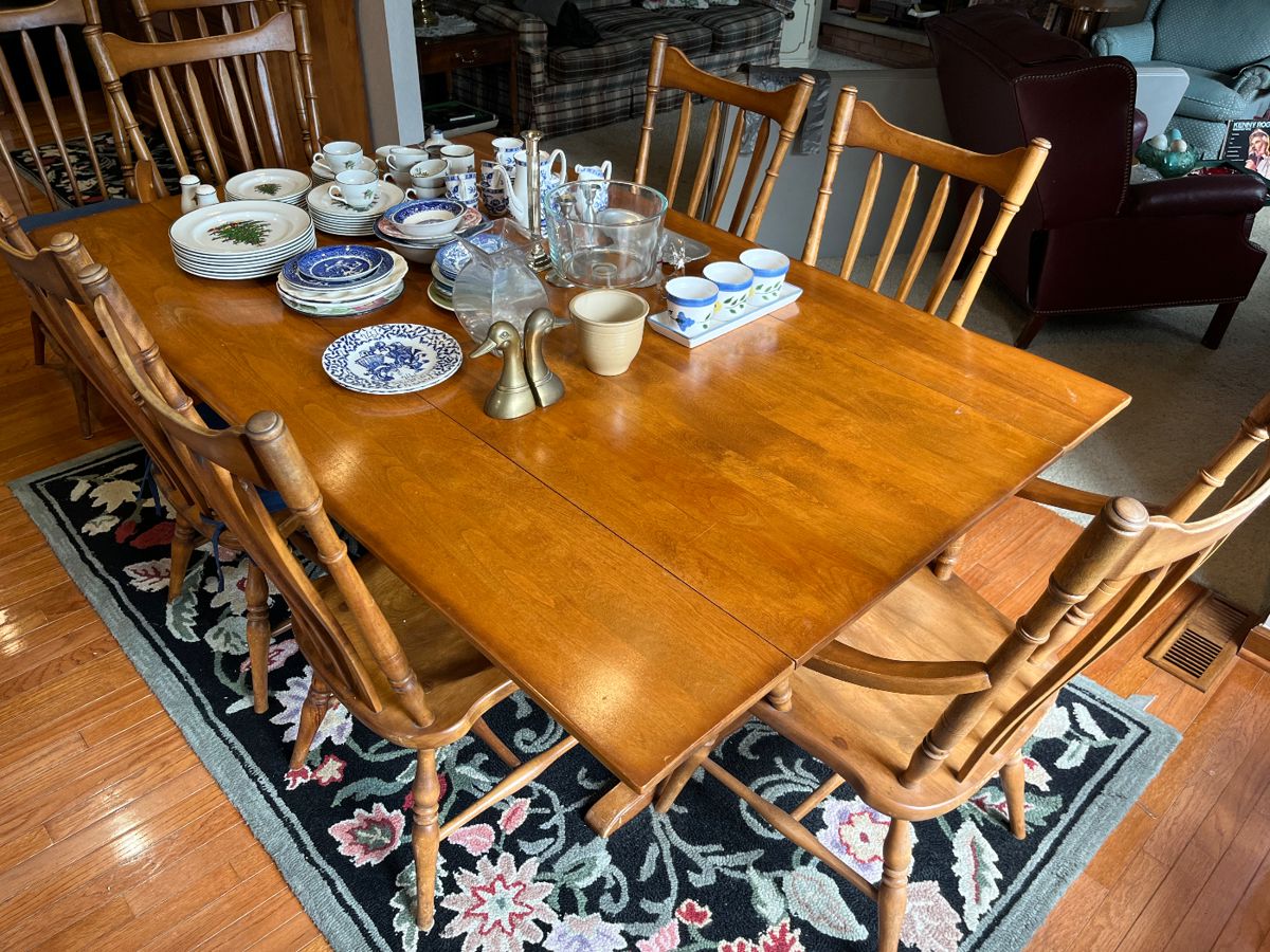 Colonial-style dining table with eight chairs and pads.