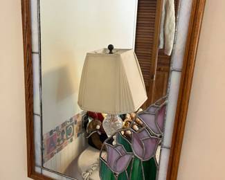 Wall mirror with stained glass border featuring tulips.