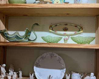 Be sure to notice the Murano style green glass swanon the second shelf. Beside it are 2 hobnail green bowls. On the shelf below is a small collection of ceramic angels and 3 very unusual candle holders. 
