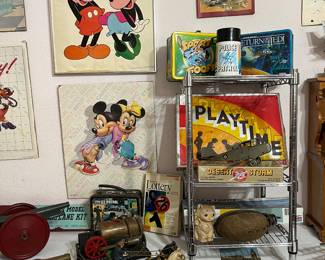 Disney pictures are on the wall.  Below on the table are VERY OLD metal toys.