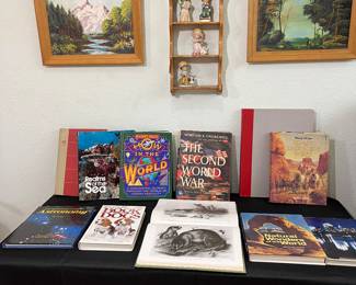 Great coffee table books are sitting on the table below the 2 mid-century framed pieces of art.