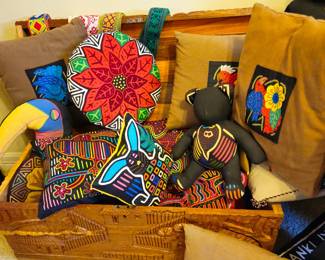 Assortment of pillows with mola covers, including a whimsical tucan