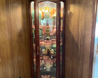 Curio cabinet filled with Hull and Roseville