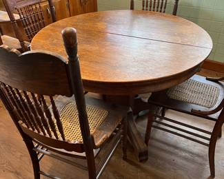 Antique round oak table with 6 chairs and 2 leaves to expand to 64"