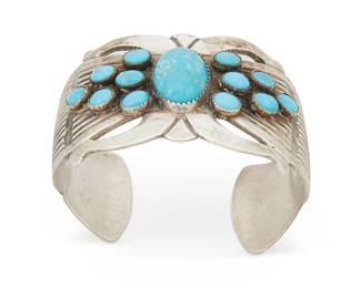 393
A Rick Martinez Navajo Silver And Turquoise Cuff Bracelet
Rick Martinez (b. 20th century, Diné)
Mid-20th century
Stamped: R. Martinez / Sterling
An openwork silver cuff with cluster set turquoise amidst chased and stamped silver accents
6.5" inner C x 1.5" H, with a 1" gap
70.5 grams gross
Estimate: $500 - $700